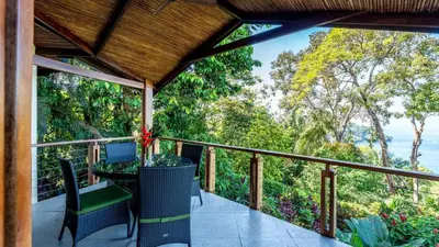a balcony of a house with a table and chairs at Tulemar in Manuel Antonio