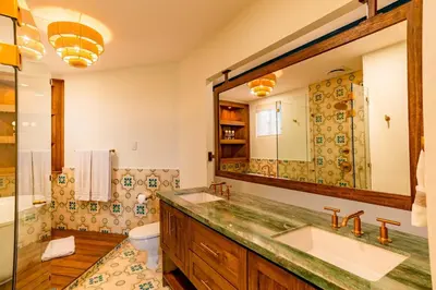 a bathroom with two sinks and a large mirror at Designer Penthouse - Bougainvillea - Reserva Conchal Golf Resortl in Playa Conchal
