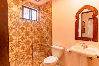 a bathroom with a toilet and a sink and a shower at Designer Penthouse - Bougainvillea - Reserva Conchal Golf Resortl in Playa Conchal