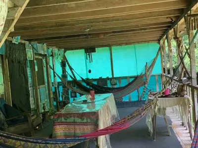 a room with a hammock in a house at Paraisoverde-Corcovado Over Night in Drake