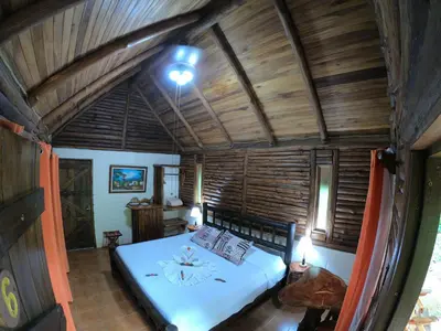 a bedroom with a bed in a room with wooden ceilings at Arenal Oasis Eco Lodge & Wildlife Refuge in Fortuna