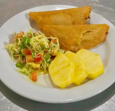 a white plate of food with salad and bread at Arenal Oasis Eco Lodge & Wildlife Refuge in Fortuna