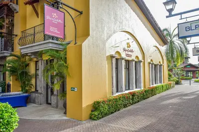 a yellow building with a sign on the side of it at Stay In CR Los Sueños Condos in Jacó