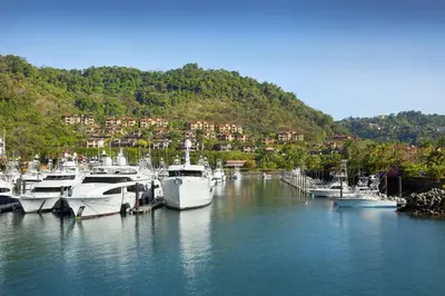 a bunch of boats docked in a marina with houses at Stay In CR Los Sueños Condos in Jacó