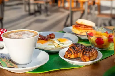 a table with plates of breakfast foods and a cup of coffee at Pacific Kalokairi - Adults Only in Tamarindo