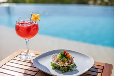 a plate of food and a drink on a table at Pacific Kalokairi - Adults Only in Tamarindo