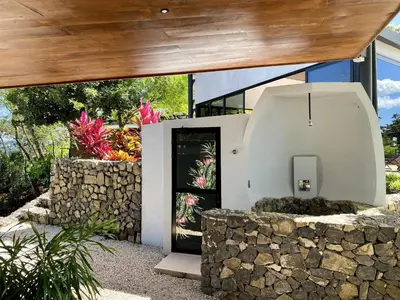 a door in a building with a stone wall at Pacific Kalokairi - Adults Only in Tamarindo