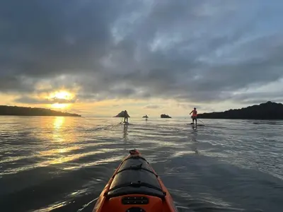 a person in a kayak in the water at sunset at OPacifico Hotel Boutique in Playa Naranjo