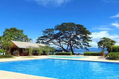 a swimming pool in front of a house with a building at OPacifico Hotel Boutique in Playa Naranjo