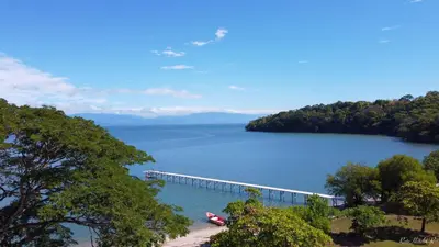 a bridge over a lake with a boat on it at OPacifico Hotel Boutique in Playa Naranjo