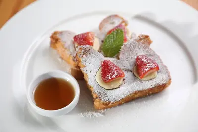 a white plate with two pieces of toast with strawberries at OPacifico Hotel Boutique in Playa Naranjo