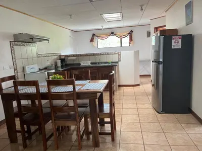 a kitchen with a table and a refrigerator at Globi Lodge #4 in Monteverde Costa Rica