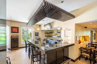 a bar in a restaurant with a counter and chairs at Four Points by Sheraton San Jose Costa Rica in San José