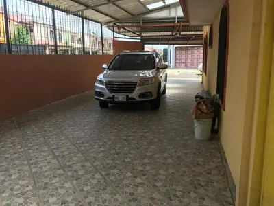 a car parked in a parking lot next to a building at Casa del Suizo in Alajuela City