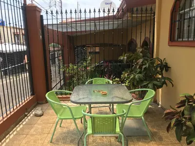 a table and four chairs on a patio at Casa del Suizo in Alajuela City