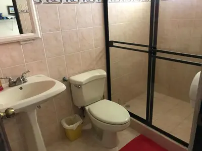 a bathroom with a toilet and a sink and a shower at Casa del Suizo in Alajuela City