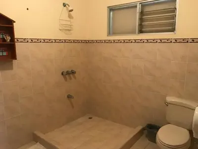 a bathroom with a shower with a toilet and a window at Casa del Suizo in Alajuela City