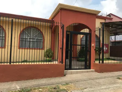 a building with wrought iron gates on a street at Casa del Suizo in Alajuela City