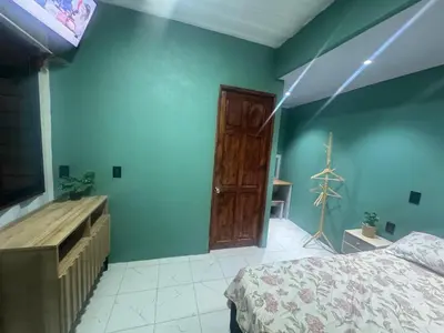 a bedroom with blue walls and a bed and a wooden dresser at The Jungle Container in Quepos