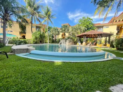 a swimming pool in a yard with a fountain at The Oaks Tamarindo Pool Front Condominiums fast wifi in Tamarindo