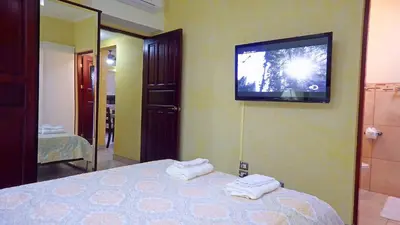 a bedroom with a bed with a television on the wall at The Oaks Tamarindo Pool Front Condominiums fast wifi in Tamarindo