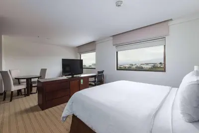 a hotel room with a bed and a desk with a television at Wyndham Garden San Jose Escazu, Costa Rica in San José