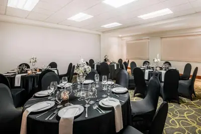 a room with a bunch of tables and chairs at Wyndham Garden San Jose Escazu, Costa Rica in San José