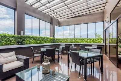 a restaurant with tables and chairs and windows at Wyndham Garden San Jose Escazu, Costa Rica in San José