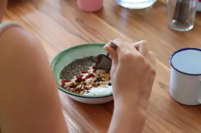 a person is eating a bowl of food on a table at Planet B Hostel - Adults Only in Manuel Antonio