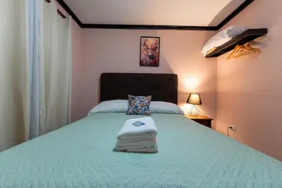 a bedroom with a green bed with towels on it at San Gabriel Apartments in Fortuna