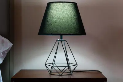 a lamp on a table with a green lamp shade at San Gabriel Apartments in Fortuna