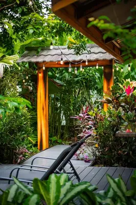 a wooden pergola with two chairs on a patio at San Gabriel Apartments in Fortuna