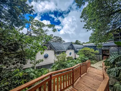 a wooden walkway leading to a white house at Monteverde Lodge by Böëna in Monteverde Costa Rica