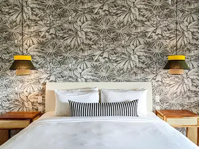 a bedroom with a bed with two lamps and a floral wallpaper at Monteverde Lodge by Böëna in Monteverde Costa Rica