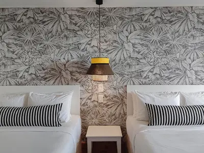 a bedroom with two beds and a wall with a tropical wallpaper at Monteverde Lodge by Böëna in Monteverde Costa Rica