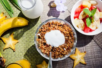 a table with a bowl of granola and a bowl of fruit at Tortuga Lodge in Tortuguero