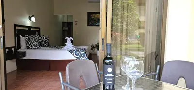 a bottle of wine sitting on a table with chairs at Hotel Monte Real in Fortuna