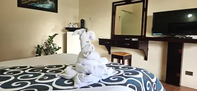 a stuffed animal sitting on a bed in a hotel room at Hotel Monte Real in Fortuna