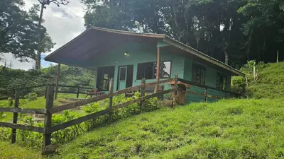 a small green house on a hill with a fence at Finca Terra Viva in Monteverde Costa Rica