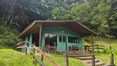 a small green house with a porch in a field at Finca Terra Viva in Monteverde Costa Rica