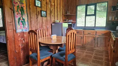 a kitchen with a table and chairs and a refrigerator at Finca Terra Viva in Monteverde Costa Rica