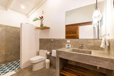 a bathroom with a sink and a toilet at Living Hotel in Nosara