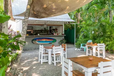 a patio with tables and chairs and a kitchen at Living Hotel in Nosara