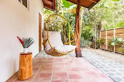 a swing on the porch of a house at Living Hotel in Nosara