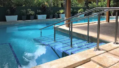 a swimming pool with stairs and potted plants at Casa Papito in Potrero