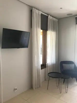 a living room with a table and a tv on the wall at Casa Papito in Potrero