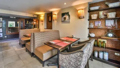 a restaurant with a table and chairs in a room at La Riviera Hotel in San José