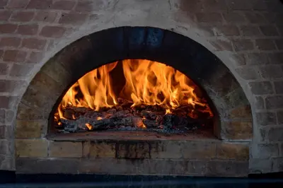 a brick oven with a fire in it at La Riviera Hotel in San José