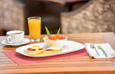 a table with a plate of food and a bowl of fruit at La Riviera Hotel in San José