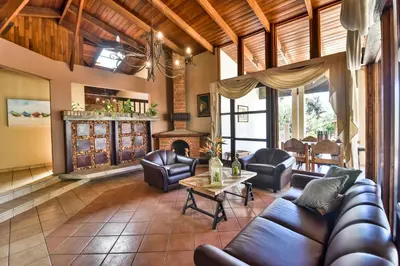 a living room with leather furniture and a fireplace at La Riviera Hotel in San José